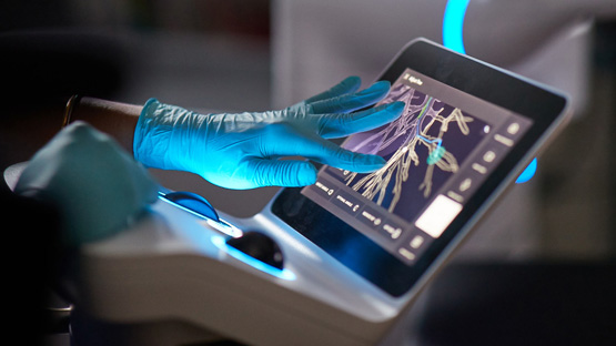 A closeup on an AHN doctors hands reviewing a scan on a medical device.